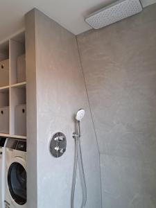 a shower in a bathroom with a washing machine at B&B The White House in Westzaan +8 photos