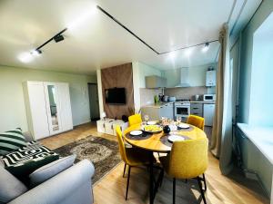 a living room with a table and yellow chairs at Vanilla Sunrise Apartments in Sillamäe