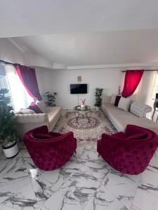 a living room with purple chairs and a marble floor at Résidence Les Camélias in Tabarka