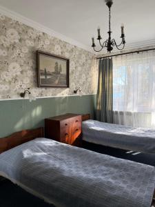 a bedroom with two beds and a chandelier at Kanu Club - ośrodek wypoczynkowy in Nowy Zyzdrój