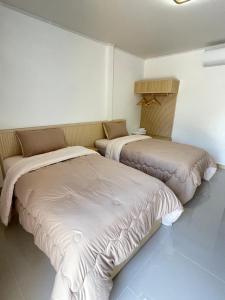 two beds in a room with white walls at แอดโฟร์รีสอร์ท in Ban Phrao