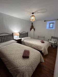 a bedroom with two beds and a chandelier at La Salera - Casa Rural in Saelices de la Sal