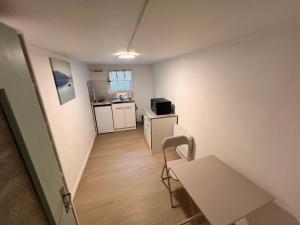 a small room with a table and a kitchen at Appartement causy in Gonfreville-lʼOrcher