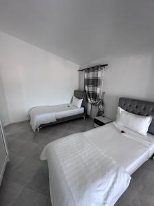 a bedroom with two beds and a couch in it at Résidence Les Camélias in Tabarka
