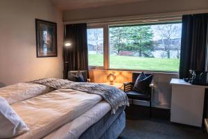 a bedroom with a bed and a large window at Thorbjørnrud Hotell in Jevnaker +99 photos
