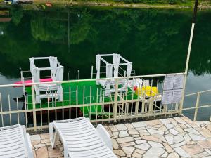 two chairs and a boat in the water at Leo Green House in Cinciş
