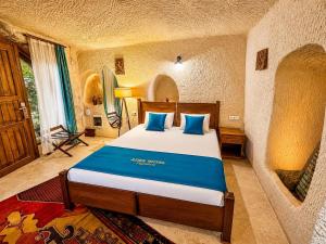 a bedroom with a large bed with blue pillows at Aden Hotel Cappadocia in Uçhisar