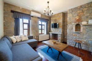 a living room with a couch and a stone wall at Salkım Otel Gökçeada in Gokceada Town