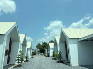 a row of white buildings with a road at แอดโฟร์รีสอร์ท in Ban Phrao