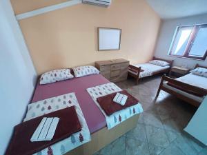 a small bedroom with two beds and a table at Hostel Obrovac in Obrovac