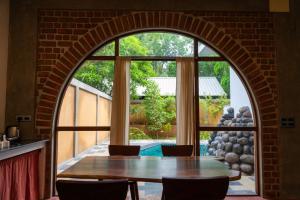 an arched window in a kitchen with a table and chairs at Mango Orchards Two in Auroville