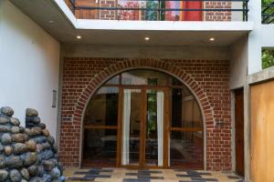 an entrance to a brick building with an archway at Mango Orchards Two in Auroville +10 photos