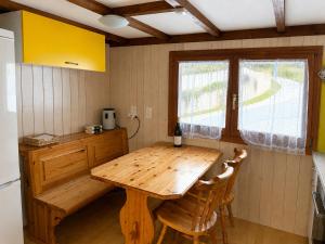 a kitchen with a wooden table and two chairs at Chalet Montana mit Bergblick in Brunig