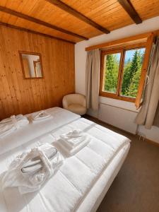 a white bed in a room with a window at Chalet Montana mit Bergblick in Brunig