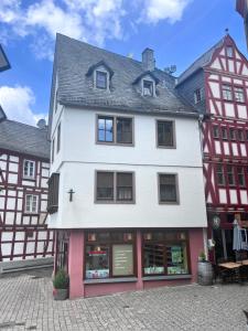 a white and red building with a store at Modernes Altstadtappartment Suite Plötze 13 Limburg in Limburg an der Lahn