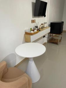 a white table and chair in a room with a tv at แอดโฟร์รีสอร์ท in Ban Phrao