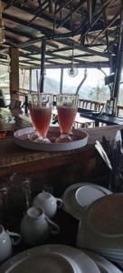 two wine glasses sitting on a table with dishes at Gotrika Valley Gesst in Ella +31 photos