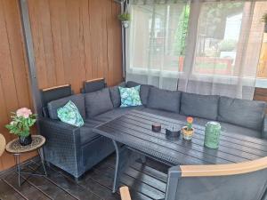 a couch and a table on a patio at Spacious Mobile Home "House Lena" for 7 in Eurocamp Rača - Sea View & Private terrace in Sveti Juraj