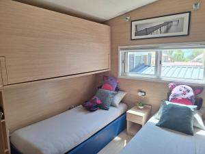 two beds in a small room with stuffed animals on them at Spacious Mobile Home "House Lena" for 7 in Eurocamp Rača - Sea View & Private terrace in Sveti Juraj