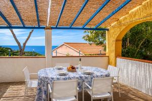 a table and chairs on a patio with a view of the ocean at Tra il Borgo e il Mare - Bel Horizonte in Capoliveri