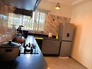 a kitchen with a stove and a refrigerator at J-Ver Haven in Kasoa