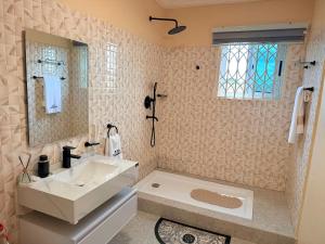 a white bathroom with a sink and a tub at J-Ver Haven in Kasoa