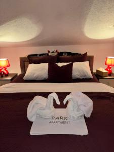 two swans towels on a bed in a bedroom at Park Apartment in Kočani