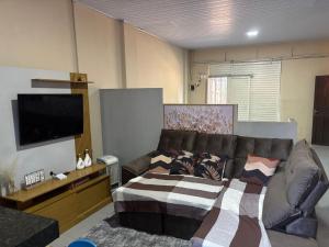 a living room with a couch and a flat screen tv at Refúgio Dom Emanuel in Pirenópolis