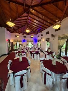 a banquet hall with red and white tables and chairs at Benvilla Kandy in Kandy