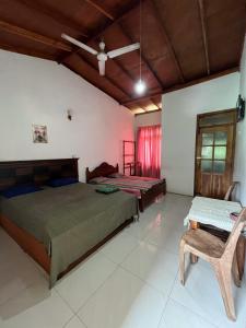 a bedroom with two beds and a chair at Benvilla Kandy in Kandy