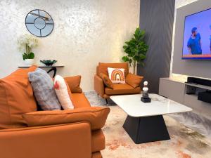a living room with orange furniture and a white table at J-Ver Haven in Kasoa