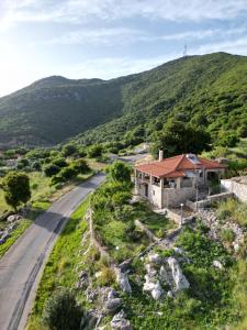 a house on a hill next to a road at Mountain Escape Villa in Gamvriá