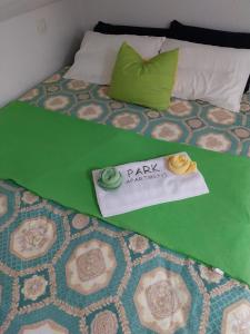 a bed with a blanket and a sign that says pay attention at Park Apartment in Kočani