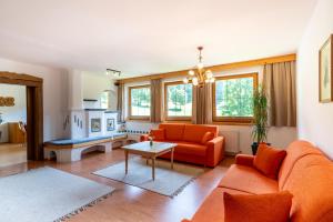 a living room with an orange couch and a table at Schi- und Wanderhotel Berghof in Bad Kleinkirchheim