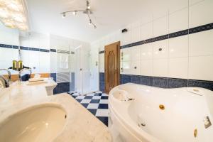 a large bathroom with a tub and two sinks and a tub at Schi- und Wanderhotel Berghof in Bad Kleinkirchheim +46 photos