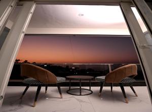 a table and chairs on a balcony with a view at Hotel Deep Khirsu in Malaī