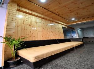 a black couch in a room with a plant at Hotel Deep Khirsu in Malaī