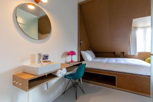 a bedroom with a bed and a sink and a mirror at Hotel BonBon & BonBon Budget in Rotterdam