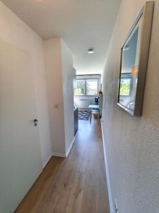 an empty room with a hallway with wooden floors at Studio calme Cite Internationale Wifi in Caluire-et-Cuire