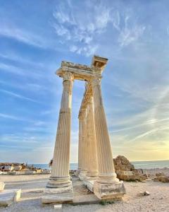 two pillars on a beach with the ocean in the background at Side Ertaş Otel in Side
