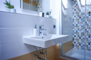 a white bathroom with a sink and a shower at Statek Český Dvůr in Postupice