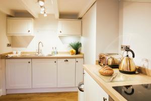 a kitchen with white cabinets and a tea kettle at Whitby Old Town Stay, Sleeps 4, The Nest in Whitby