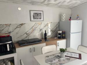 a kitchen with white cabinets and a counter with a table at Il BORGO in Lapedona