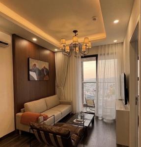a living room with a couch and a chandelier at Anmie Home - Hoàng Huy CMC in An Khê