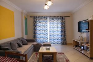 a living room with a couch and a table at Casa Dòdò - Sunny Lakes Compound in Sharm El Sheikh