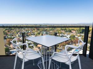 a table and two chairs on a balcony with a view at The Sebel Melbourne Malvern in Melbourne