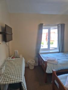 a hotel room with two beds and a window at ACCOMADATION WREXHAM in Wrexham