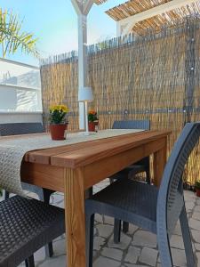 a wooden table and chairs on a patio at Broom House in San Foca