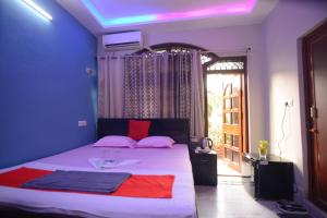 a bedroom with a bed with pink pillows and a window at Harshita's Guest House in kolkata