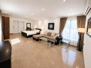 a large living room with a bed and a couch at La Plage Bungalow in Dubai